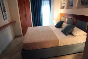 um quarto com uma cama com duas almofadas e uma janela em Albatros Suite Home em Pozzuoli