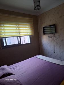 ein Schlafzimmer mit einem großen Bett und einem Fenster in der Unterkunft Blanca beach in Sidi Rahal