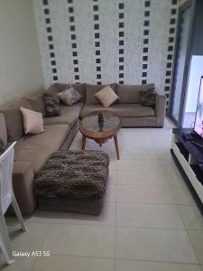 een woonkamer met een bank en een salontafel bij Blanca beach in Sidi Rahal