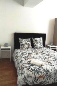 um quarto com uma cama com um edredão preto e branco em L'Envol em Orléans