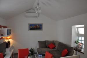 sala de estar con sofá y sillas rojas en Apartment Sweet Home en Split