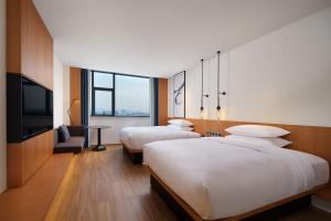a hotel room with two beds and a flat screen tv at Fairfield by Marriott Yuyao in Yuyao