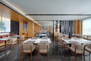 een eetkamer met witte tafels en stoelen bij Fairfield by Marriott Yuyao in Yuyao