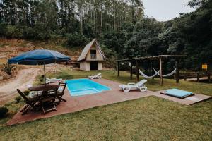 an overhead view of a backyard with a pool and an umbrella at Recanto da Serra Chalé 02 in Mauá da Serra