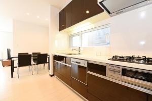 cocina con encimeras blancas y mesa con sillas en Sapporo - House - Vacation STAY 14578 en Sapporo