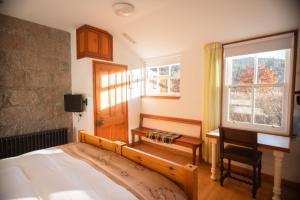 a bedroom with a bed and a desk and a window at Schoolhouse Ballater B&B in Ballater