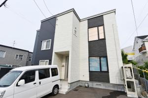 Sapporo - House - Vacation STAY 14578 في سابورو: سيارة فان بيضاء متوقفة أمام منزل