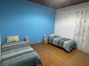 - une chambre avec 2 lits et un mur bleu dans l'établissement Tropical Paradise, à São Tomé