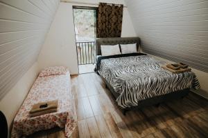 a small room with a bed and a swing at Recanto da Serra Chalé 02 in Mauá da Serra +83 photos