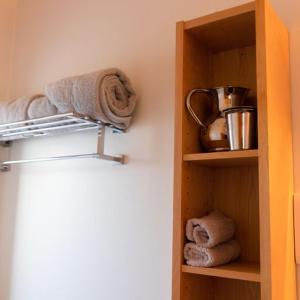 a cupboard with towels and a tea kettle and towels at Schoolhouse Ballater B&B in Ballater