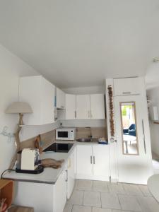 eine weiße Küche mit weißen Schränken und einem Fenster in der Unterkunft Studio Golfe Juan, plages, parking, climatisation in Vallauris