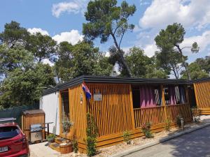 a house with an orange fence and a red car at Mobile home Linico in Biograd na Moru