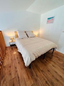 - une chambre avec un grand lit et du parquet dans l'établissement Duplex à 5min de Disneyland Paris, à Montévrain