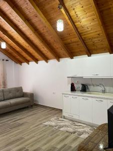 ein Wohnzimmer mit einem Sofa und einer Küche in der Unterkunft P&K apartment Pogradec in Pogradec