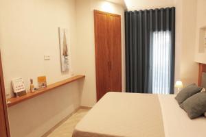 um quarto de hotel com uma cama e uma janela em Albatros Suite Home em Pozzuoli