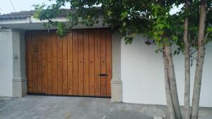uma porta de garagem de madeira com uma parede branca em L´Aurora Inn hostal em Guatemala