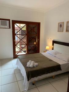 a bedroom with a bed with two towels on it at Casa H11 em condomínio fechado frente a praia Maresias in São Sebastião