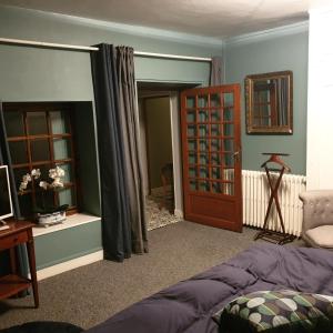 um quarto com uma cama e uma porta com uma janela em Cour st Didier em Nevers
