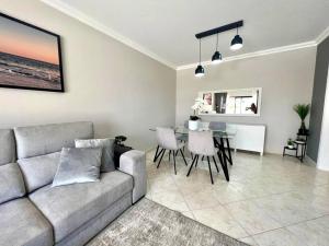 ein Wohnzimmer mit einem Sofa und einem Tisch in der Unterkunft Luxury Modern Beach Apartment in Quarteira