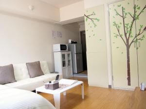 a living room with a white couch and a tree on the wall at Live Kyoto Kitaoji - Vacation STAY 13929 in Kyoto