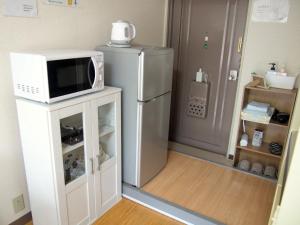 uma cozinha com um frigorífico e um micro-ondas num armário em Live Kyoto Kitaoji - Vacation STAY 13926 em Quioto