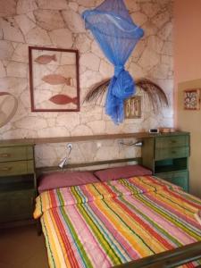 a bedroom with a bed and a stone wall at Casita Solemar direkt am Atlantik in Calheta Do Maio