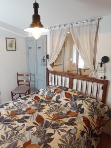- une chambre dotée d'un lit avec un couvre-lit floral dans l'établissement Zoé, à Chervettes