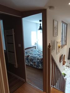 a bedroom with a bed and a hallway with a mirror at Gîte Zoé in Chervettes +10 photos