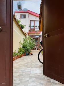 an open door leading to a courtyard with plants at Vila Kodra in Tirana