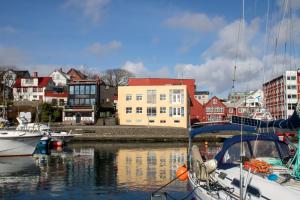 a group of boats docked in a harbor with buildings at Guesthouse at the boat harbour in Tórshavn