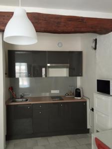 cocina con armarios negros y techo blanco en Studio tout confort en Provence Mont Ventoux., en Bédoin