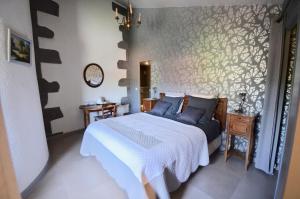 a bedroom with a bed with blue pillows at Le Moulin des Poètes in Malauzat +34 photos