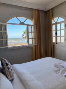 a bedroom with a bed and a view of the beach at AMWAJ HOTEL in El Jadida