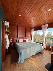 um quarto com uma cama e um tecto em madeira em Cabanas Românticas em meio a Natureza - Anitápolis/SC - CB05 em Annitapolis