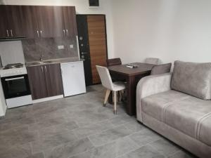 a living room with a couch and a table and a kitchen at Apartman Jela in Soko Banja