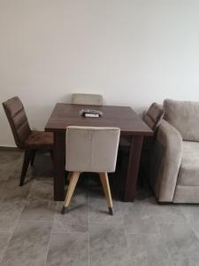 a wooden table with a chair and a couch at Apartman Jela in Soko Banja +1 photo