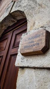 una señal en el lateral de un edificio al lado de una puerta en Il Rifugio del Brigante en Sante Marie