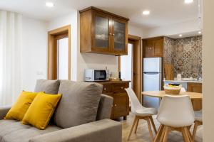 a living room with a couch and a kitchen with a table at Casa da Fonte in Vilarelhos