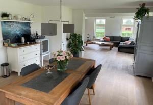 una cocina y una sala de estar con una mesa con flores. en De Grote Drent, 