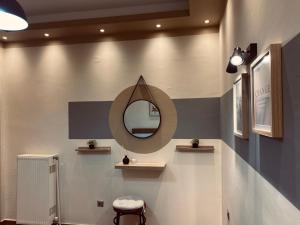 ein Badezimmer mit einem Spiegel an der Wand und einem Stuhl in der Unterkunft Minimal & cozy ΔΙΑΜΕΡΙΣΜΑ ΜΕ ΔΩΡΕΑΝ ΧΩΡΟ ΣΤΑΘΜΕΥΣΗΣ in Kavala
