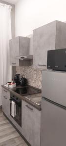 una cucina con piano cottura e frigorifero di Casa Cosmedin a Napoli