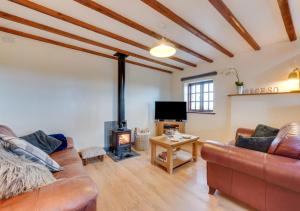 a living room with a couch and a fireplace at Y Beudy in Y Felinheli