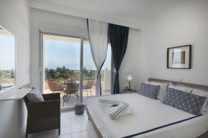 a bedroom with a bed and a balcony at Kahlenberg apartments in Afitos