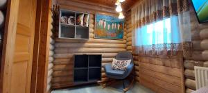 a room with a wooden wall with a chair and a window at Reykjavik 116 Cozy Mini Studio 14m2 On Road no1 28km from the center of Rvk in Kjalarnes