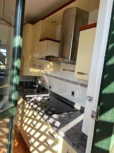 uma cozinha com armários brancos e um balcão preto em Bonito dúplex con vistas al mar em Comillas