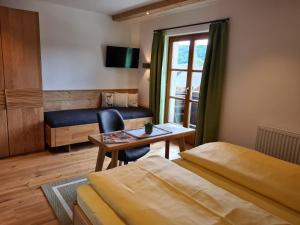 1 Schlafzimmer mit 2 Betten, einem Tisch und einem Fenster in der Unterkunft Appartements Macheiner in Mariapfarr