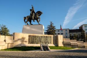a statue of a man on a horse in a city at Pandora Central Apartment in Cluj-Napoca