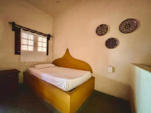 a bedroom with a bed with plates on the wall at Hotel Rancho Escondito in Puerto Escondido