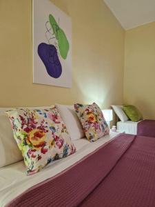 um quarto com uma cama com almofadas coloridas em CIVICO 26 em Bisceglie