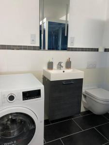a bathroom with a washing machine and a sink at Moderne EG 2-Zimmer Wohnung in Trier